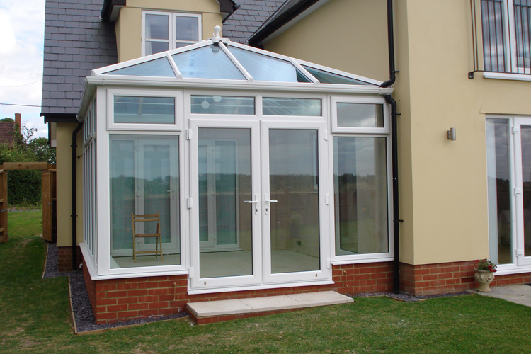 White PVC Double Hip Edwardian with Box Gutter to house walls, solar control self cleaning glass roof & French doors