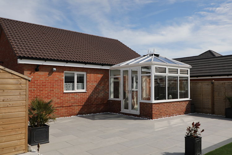 White PVC Double Hip Edwardian with Box Gutter to house wall, solar control self cleaning glass roof & French doors